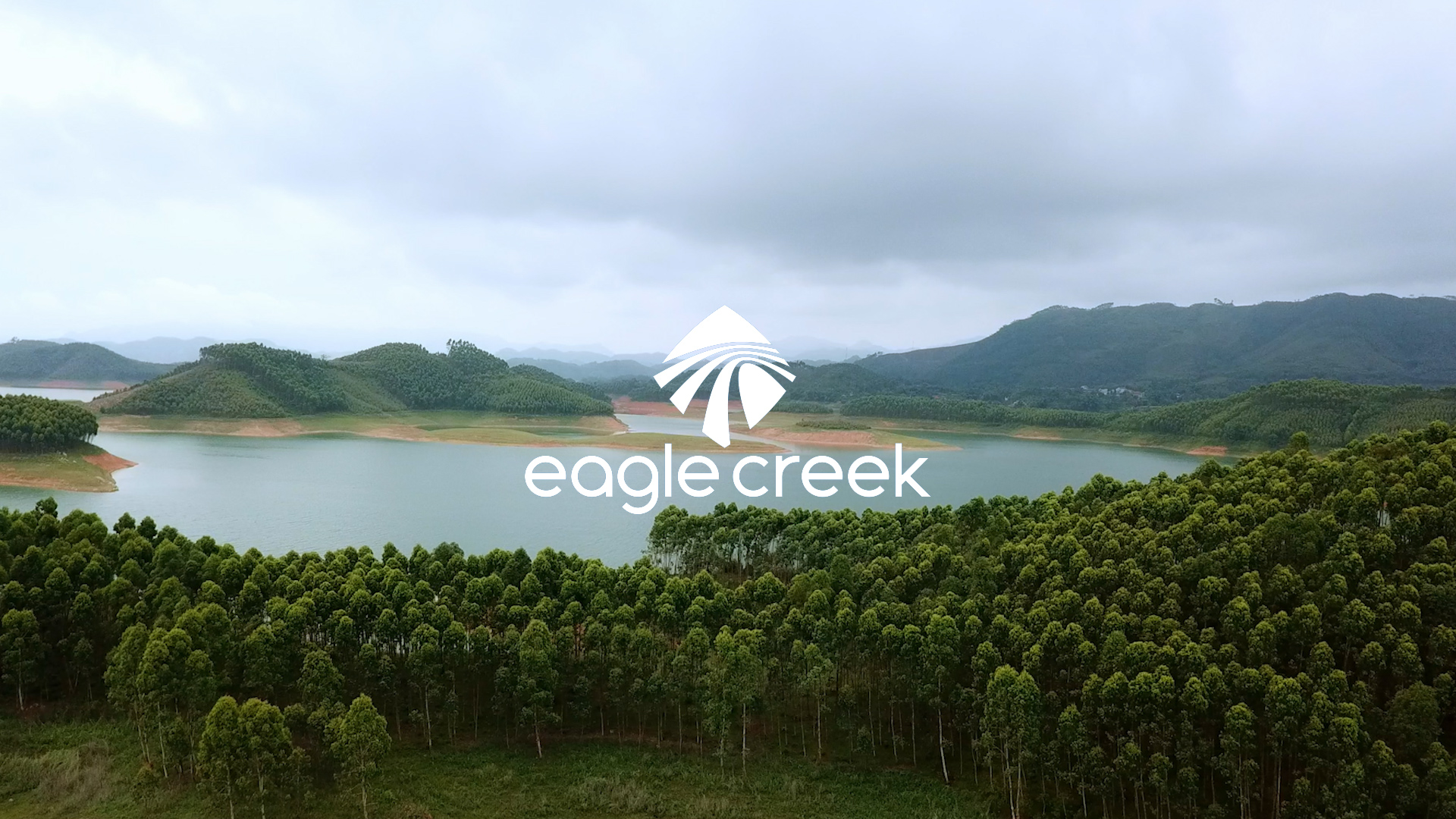 Eagle Creek logo on top of image of a green forest and river.