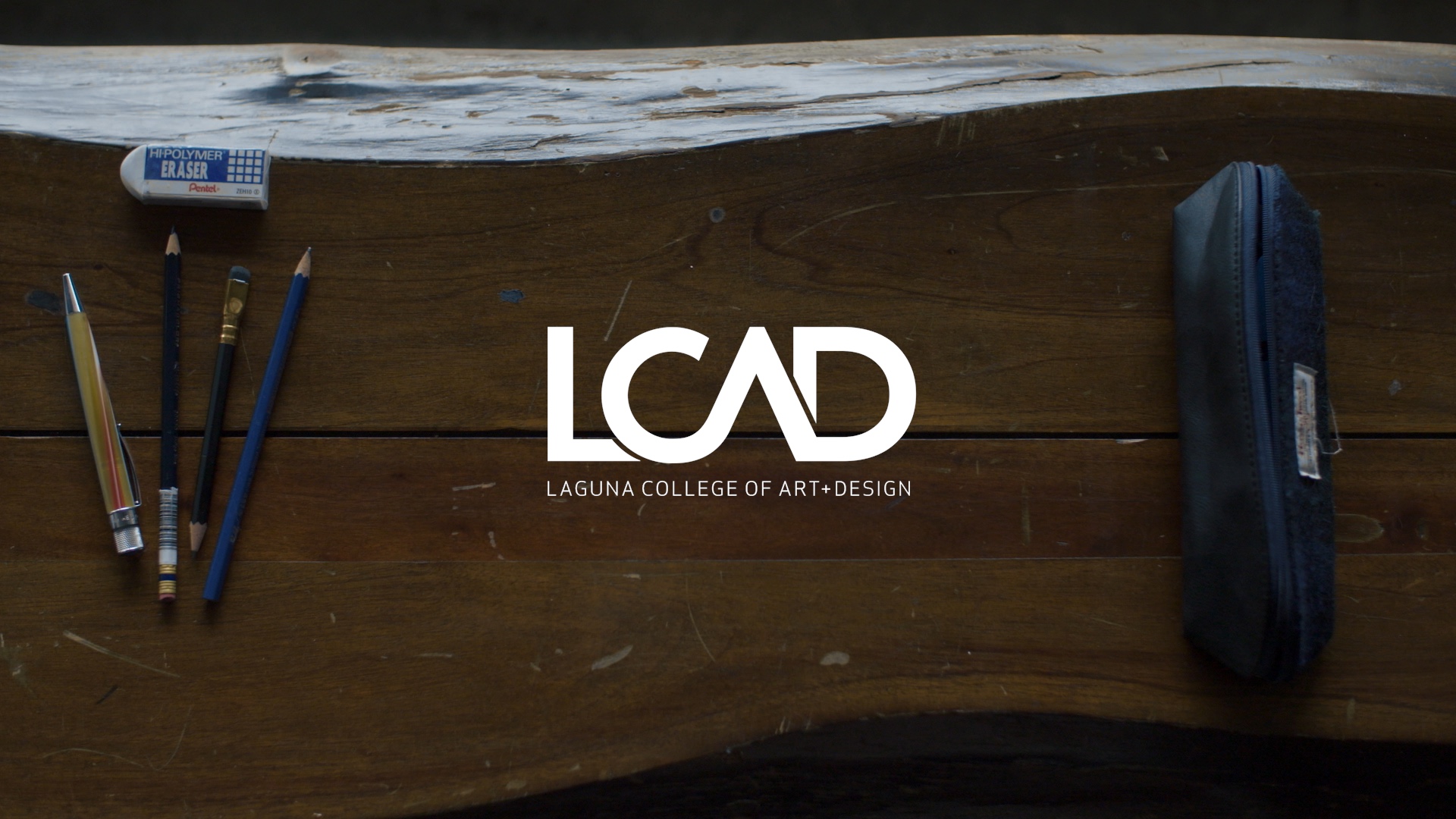 LCAD logo on top of artist's desk with art supplies.